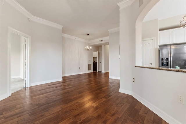 unfurnished living room featuring baseboards, dark wood finished floors, arched walkways, crown molding, and a notable chandelier