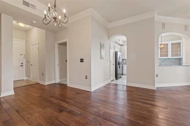 interior space with arched walkways, a notable chandelier, visible vents, and wood-type flooring