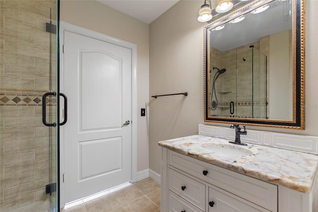 bathroom with tile patterned flooring, a stall shower, vanity, and baseboards