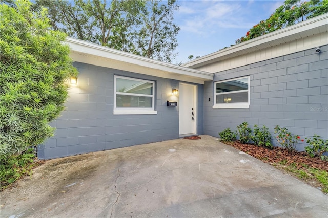 doorway to property with a patio area and concrete block siding