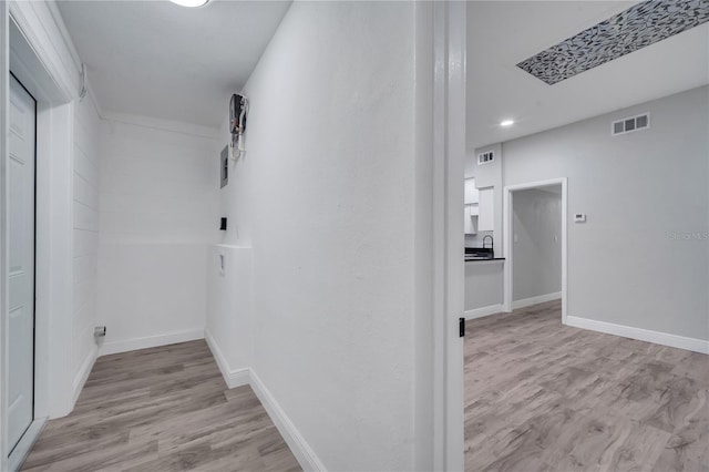 corridor with light wood finished floors, baseboards, visible vents, and recessed lighting