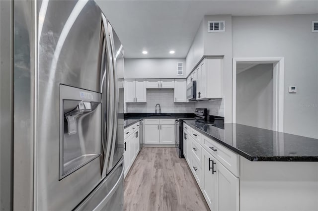 kitchen with stainless steel fridge with ice dispenser, electric range oven, dark stone countertops, light wood-type flooring, and white cabinets