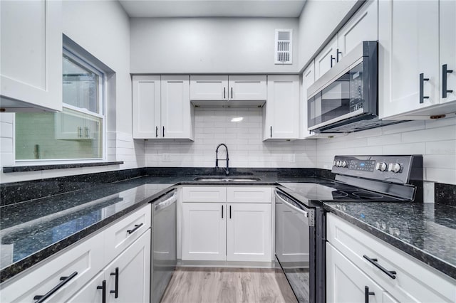 kitchen with light hardwood / wood-style flooring, stainless steel appliances, sink, and white cabinetry