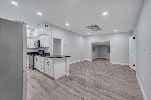 kitchen with light hardwood / wood-style flooring, appliances with stainless steel finishes, white cabinets, and decorative backsplash