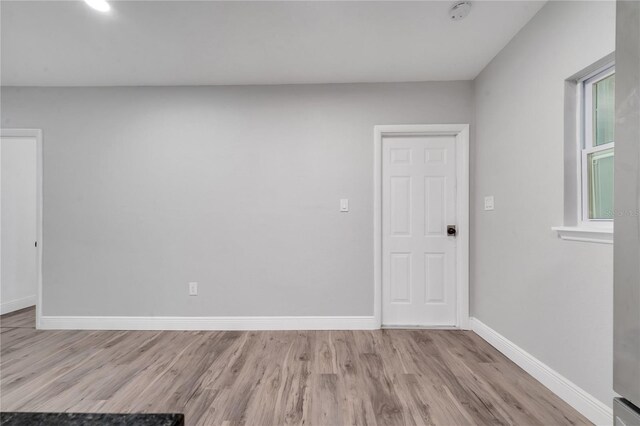 unfurnished room with a healthy amount of sunlight and light hardwood / wood-style floors