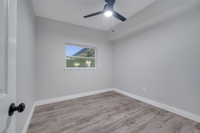 empty room featuring a ceiling fan, baseboards, and wood finished floors