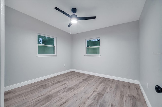 unfurnished room with ceiling fan, wood finished floors, and baseboards