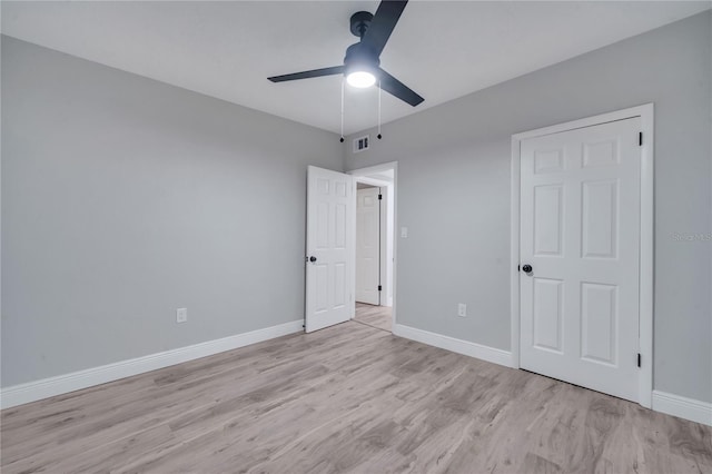 unfurnished bedroom featuring light wood finished floors, a ceiling fan, visible vents, and baseboards