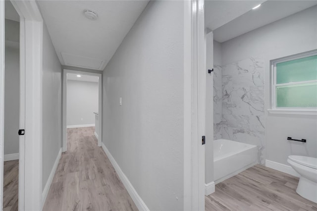 bathroom featuring toilet, hardwood / wood-style flooring, and tiled shower / bath