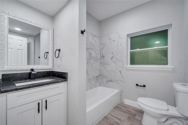 full bathroom with tiled shower / bath combo, toilet, hardwood / wood-style flooring, and vanity