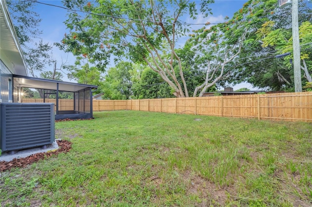 view of yard featuring a fenced backyard and central AC