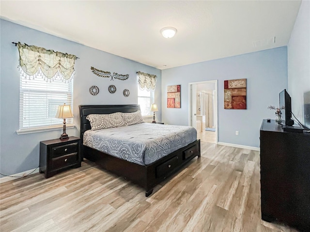 bedroom featuring light hardwood / wood-style floors and connected bathroom