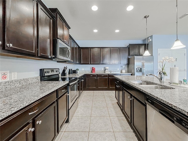 kitchen featuring dark brown cabinetry, sink, decorative light fixtures, and stainless steel appliances