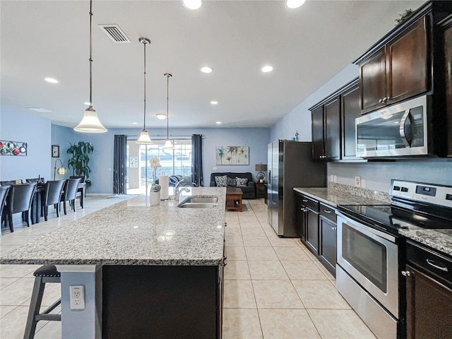 kitchen featuring a breakfast bar area, a spacious island, sink, pendant lighting, and stainless steel appliances