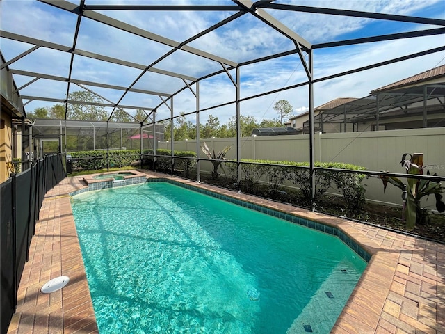 view of swimming pool featuring an in ground hot tub, a patio area, and glass enclosure