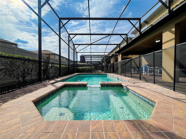 view of pool with an in ground hot tub, a patio, and a lanai