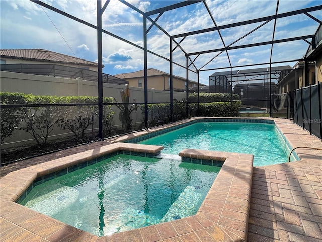 view of pool featuring a lanai and an in ground hot tub