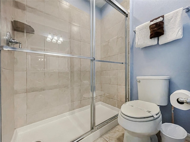 bathroom with tile patterned flooring, toilet, and walk in shower