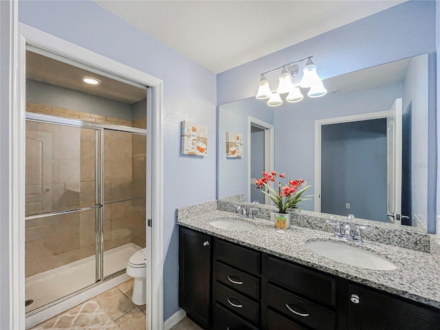 bathroom featuring a shower with door, vanity, toilet, and tile patterned floors