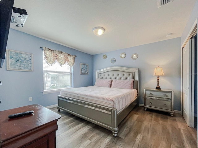 bedroom with dark wood-type flooring and a closet