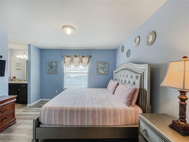 bedroom featuring ensuite bathroom and light hardwood / wood-style floors