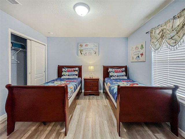 bedroom with hardwood / wood-style floors and a closet