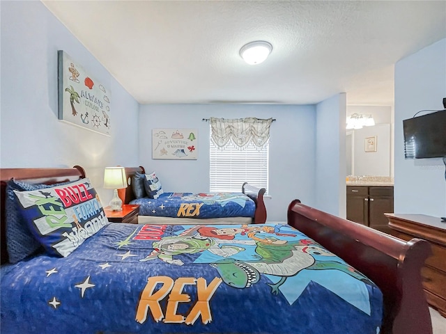 bedroom with a textured ceiling and ensuite bath