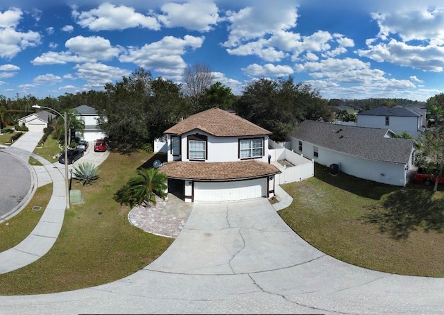 view of front facade featuring an attached garage, stucco siding, concrete driveway, and a front yard