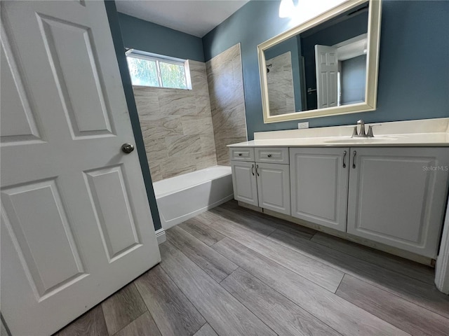 bathroom featuring shower / tub combination, wood finished floors, and vanity