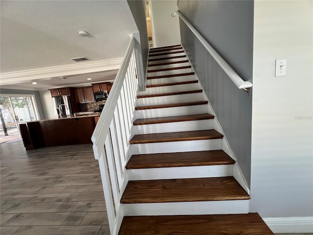 stairway with recessed lighting, visible vents, and wood finished floors