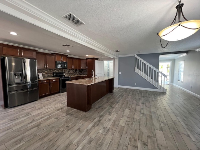 kitchen with black microwave, range with electric cooktop, visible vents, open floor plan, and stainless steel fridge with ice dispenser