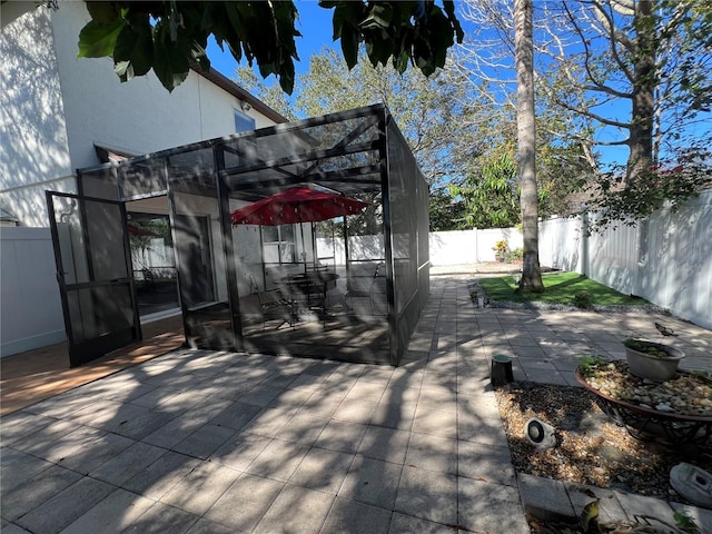 view of patio with a lanai and a fenced backyard