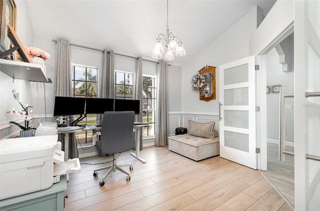 office area featuring light wood-type flooring, high vaulted ceiling, and an inviting chandelier