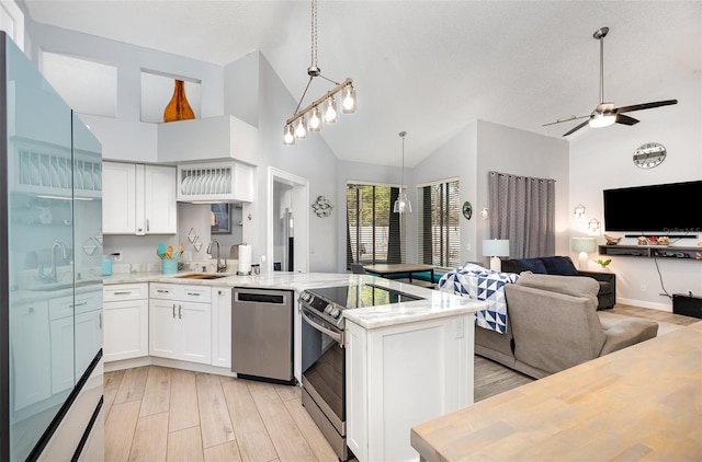 kitchen featuring light wood-type flooring, high vaulted ceiling, sink, ceiling fan, and appliances with stainless steel finishes