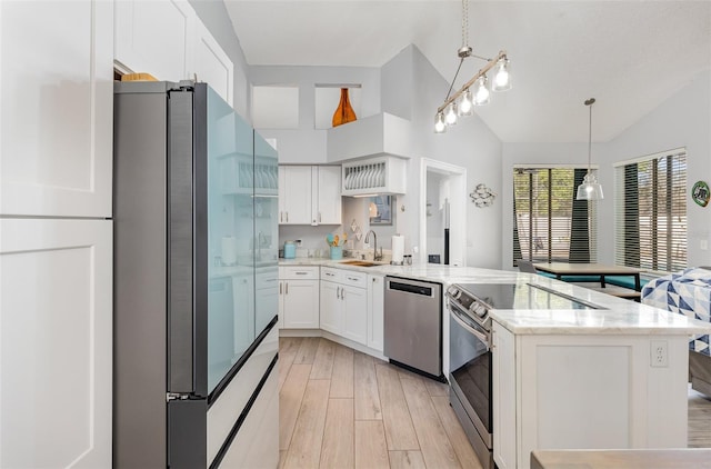 kitchen featuring decorative light fixtures, appliances with stainless steel finishes, lofted ceiling, light stone counters, and light wood-type flooring