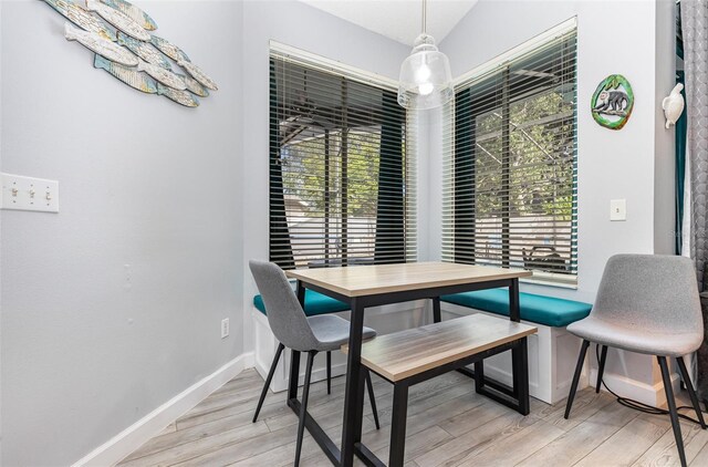 dining area featuring lofted ceiling and light hardwood / wood-style flooring