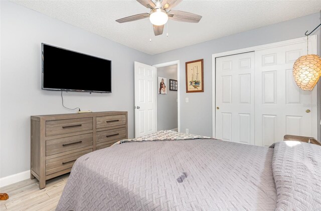 bedroom featuring a closet, a textured ceiling, ceiling fan, and light hardwood / wood-style floors