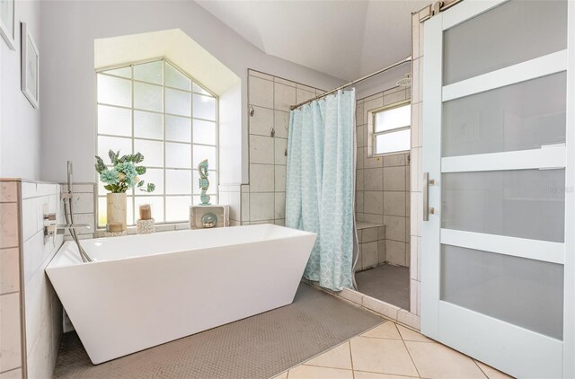 bathroom featuring tile walls, independent shower and bath, and tile patterned floors