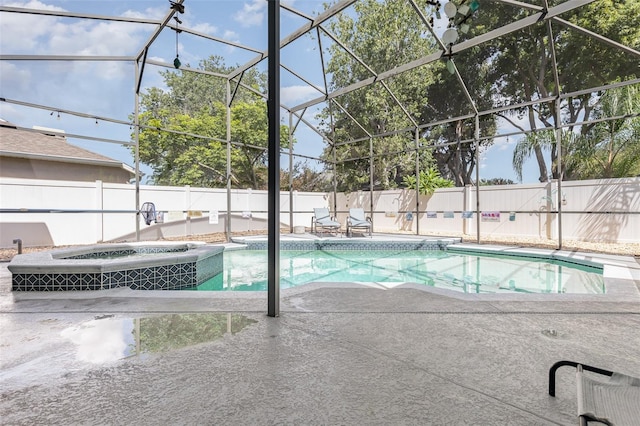 view of pool with glass enclosure, a patio, and an in ground hot tub