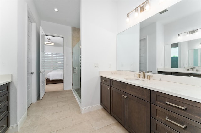 bathroom featuring a shower with door, vanity, plenty of natural light, and tile patterned floors