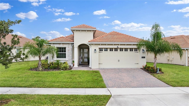 mediterranean / spanish home featuring a front yard and a garage