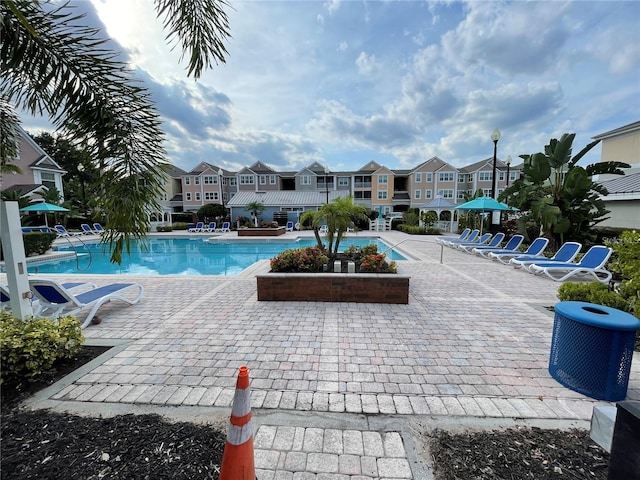view of swimming pool with cooling unit and a patio