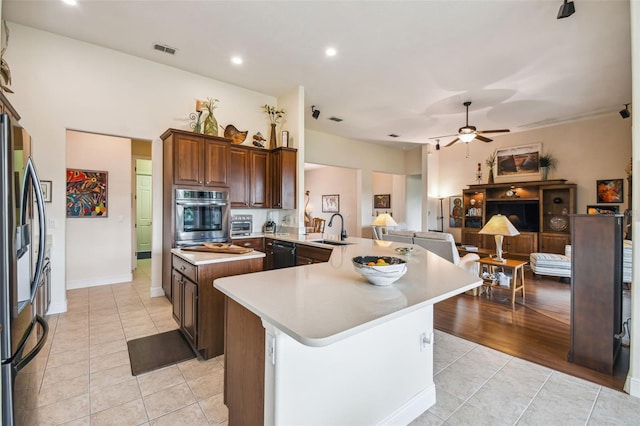 kitchen with kitchen peninsula, sink, stainless steel appliances, ceiling fan, and light tile patterned flooring