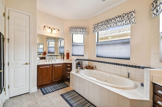 bathroom with tile patterned flooring, vanity, and a relaxing tiled tub