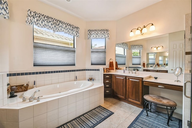 bathroom with tiled tub, vanity, and tile patterned floors