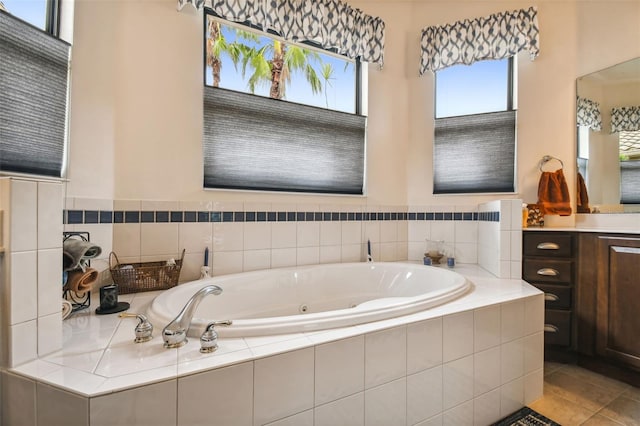 bathroom with vanity, a relaxing tiled tub, and tile patterned flooring