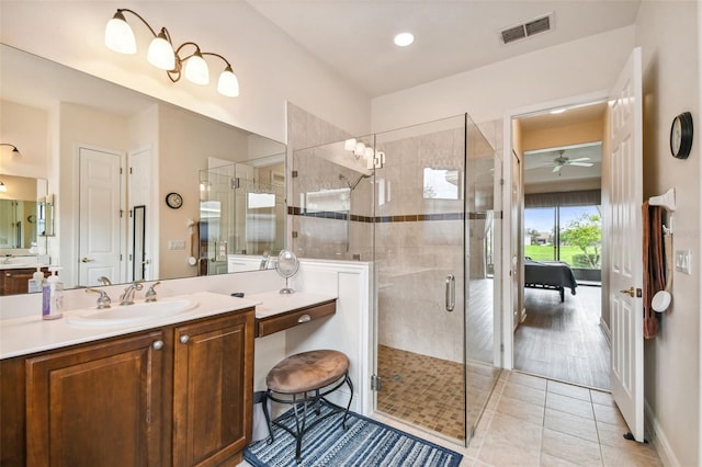 bathroom featuring a shower with door, vanity, ceiling fan, and tile patterned floors