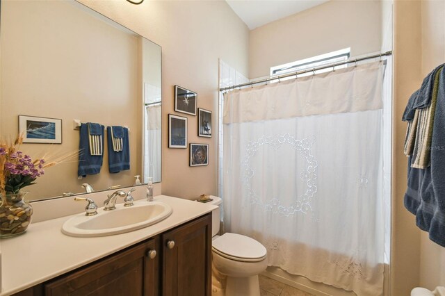 full bathroom featuring shower / bath combination with curtain, tile patterned flooring, toilet, and vanity