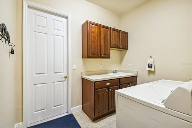 clothes washing area with light tile patterned floors, sink, cabinets, and washing machine and dryer