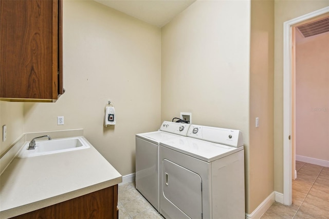 washroom featuring separate washer and dryer, cabinets, sink, and light tile patterned flooring